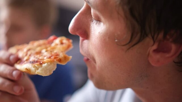 Caucasian kid boy and his father eating junk food at home. Single Father and son fast food, unhealthy food concept. Part of series