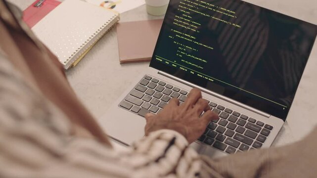 Writes program code on the laptop
