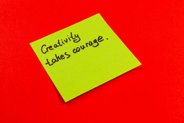 Inspirational quote on a sticky note against a bright red background