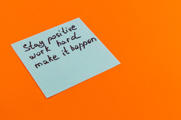 Motivational note on orange background encouraging positivity and hard work