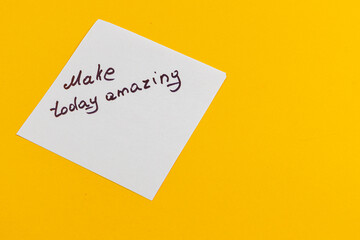 Motivational note on a bright yellow background encouraging a positive day
