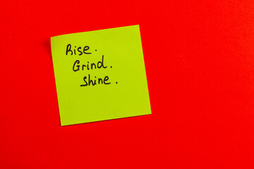 Motivational sticky note on bright red background encouraging daily effort