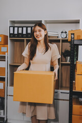 Asian SME business women use laptop computer checking customer order online shipping boxes at home....