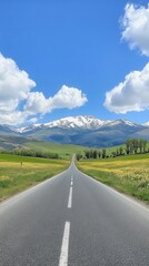 Scenic Road Leading to Snow Capped Mountain Range Under a Blue Sky with Fluffy Clouds in a Serene Landscape