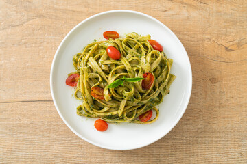 fettuccine spaghetti pasta with pesto sauce and tomatoes