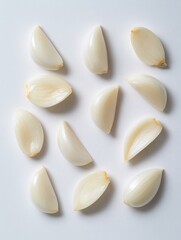 Peeled garlic cloves displayed on a white background highlight their smooth texture and pale hue, making them perfect for culinary themes and food projects focused on freshness and flavor.