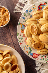 Delicious Homemade  walnut shaped shortbread  cookies filled with sweet condensed milk on colorful dish  on wooden table