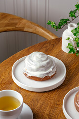 cinnabon with white cream on a plate