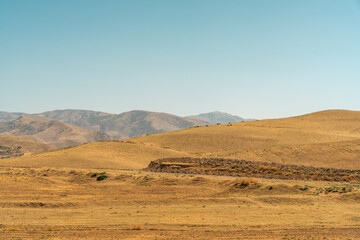 A vast, empty desert with a clear blue sky