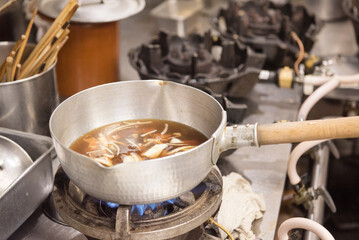 Simmering pot of Japanese broth cooking over a gas stove in a kitchen