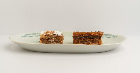 Delicious pastry assortment featuring layered desserts on a decorative plate in bright lighting