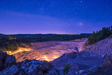Gordijnen Night sky over quarry with twinkling stars and illuminated rocks in rural landscape © Andrii_Hrabchuk