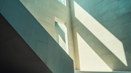 Obraz premium Sunlight streams through modern architecture, illuminating stone walls and stairs.