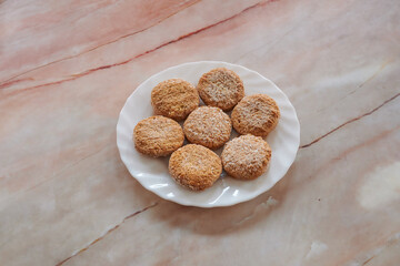 A plate of cookies sits on a marble countertop