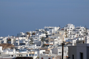Fototapeta premium Whitewashed church and houses overlooking sparkling aegean sea in santorini, greece