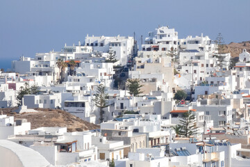 Fototapeta premium Whitewashed church and houses overlooking sparkling aegean sea in santorini, greece