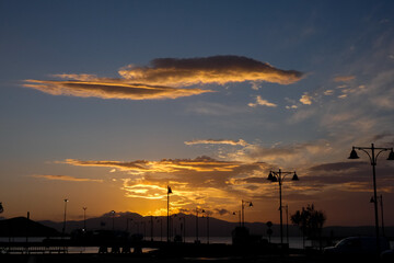 Street lamps silhouetted against a vibrant sunset sky