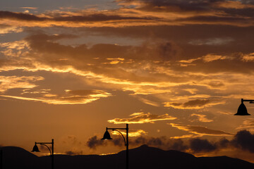 Street lamps silhouetted against a vibrant sunset sky