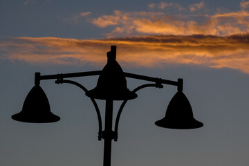 Street lamps silhouetted against a vibrant sunset sky