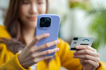 Asian woman using credit card.Happy cheerful girl enjoying online shopping,using ecommerce app on smartphone,paying for purchase, order by credit card,buying goods on Internet.online shopping concept.