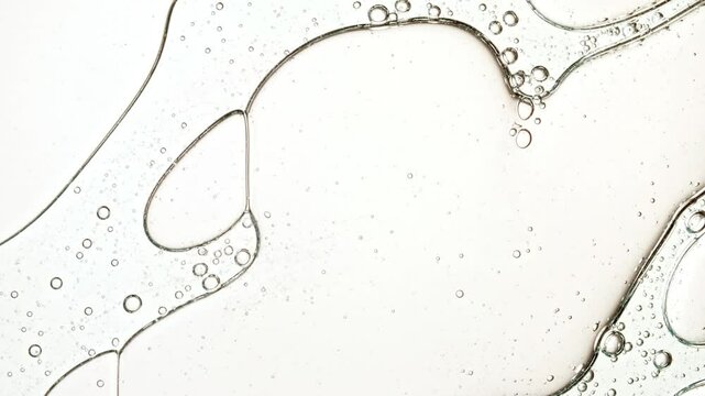 Transparent cosmetic gel fluid with molecule bubbles oil distribution. Bubble cluster, cells under a microscope. Macro Shot of Natural Organic Cosmetics, Medicine. Production Close-up. Slow Motion. 4k