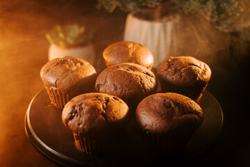 Freshly baked chocolate muffins arranged on a wooden table in a cozy setting