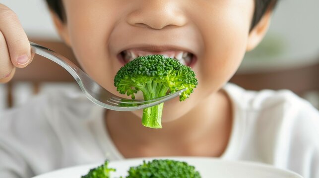 Child eating broccoli from plate.