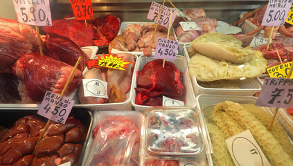 pieces of offal and animal innards such as kidneys or stomach with italian names for sale in a butcher shop in italy