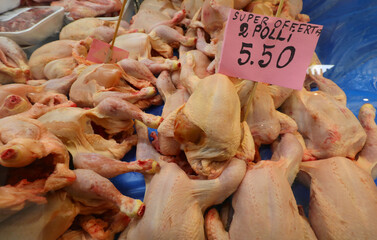 raw plucked chickens for sale on the counter of the butcher shop specializing in poultry meat with...