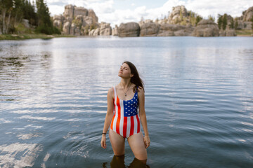 Woman in patriotic swimsuit standing in Sylvan Lake, SD.