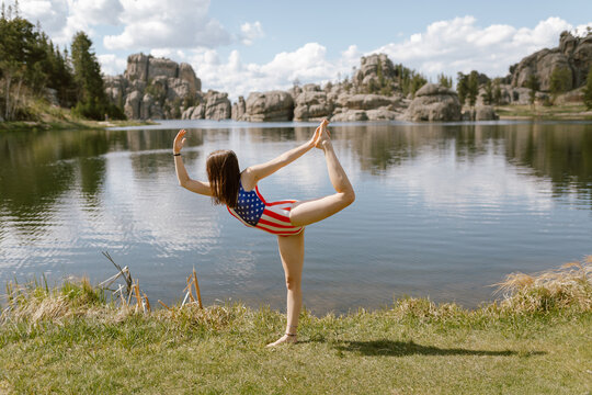Woman in patriotic swimsuit doing yoga by Sylvan Lake, SD.