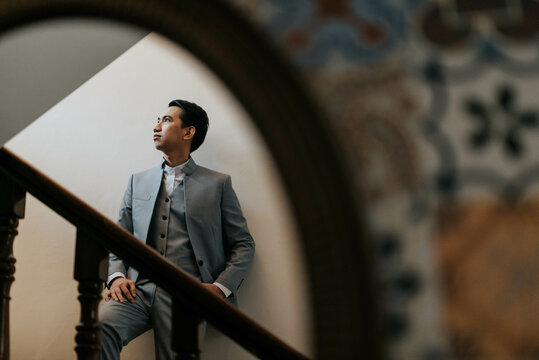 Young Man Looking Away from a Mirror on a Staircase