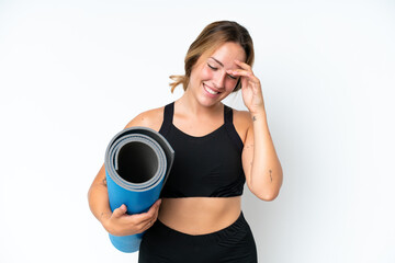 Young caucasian woman going to yoga classes while holding a mat isolated on white background...