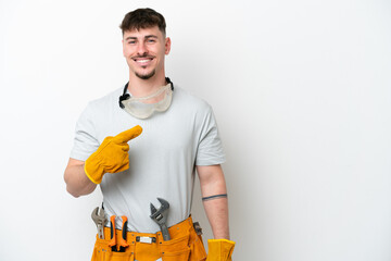 Young caucasian electrician man isolated on white background pointing to the side to present a...