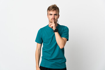 Obraz premium Young handsome man isolated on white background showing a sign of silence gesture putting finger in mouth