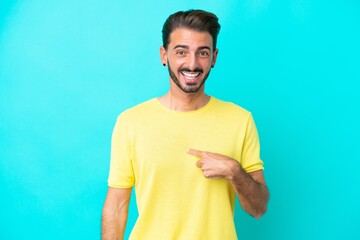 Young caucasian man isolated on blue background with surprise facial expression