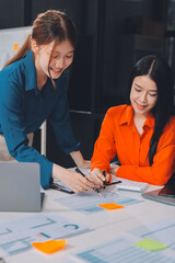 Entrepreneur Asian businessman and businesswoman discussing new business project in tablet in modern Meeting In Modern Office, Asian business casual concept.