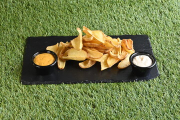 Naklejka premium A plate of french fries with two condiments, one of which is mustard
