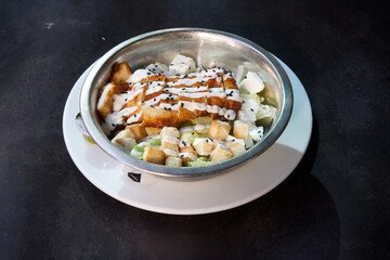 A bowl of food with a white plate underneath it