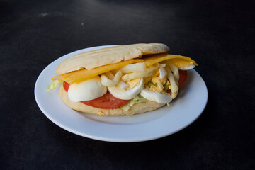 A sandwich with cheese and eggs on a white plate