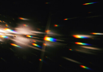 Abstract light leak effect with scattered streaks and flares of rainbow light burst, grainy textured across on  black background