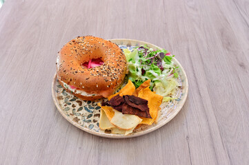 A plate of food with a sandwich, chips, and salad