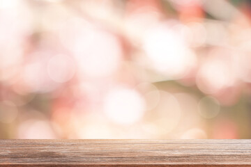 Wood table top on blur abstract green and pink from sunlight in the morning for product design...