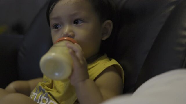 Toddler Is Drinking Milk From A Bottle, Video footage for documentary and cinematic in dink milk scene.