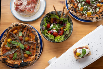A table with a variety of food, including pizza, salad, and a dessert