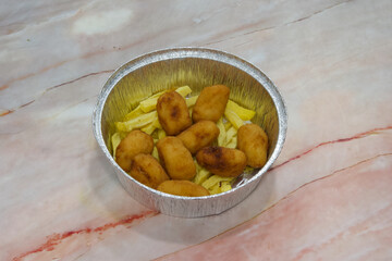 A bowl of fried chicken and french fries