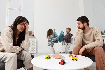 Overwhelmed parents and their naughty children at home