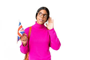 Young African American woman holding an United Kingdom flag over isolated chroma key background listening to something by putting hand on the ear
