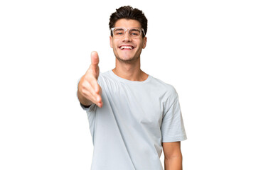 Young caucasian handsome man over isolated background shaking hands for closing a good deal