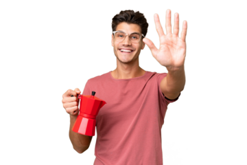 Young caucasian man holding coffee pot over isolated background saluting with hand with happy expression